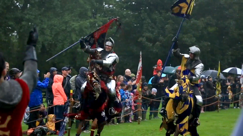 Film still of medieval knights in front of crowd