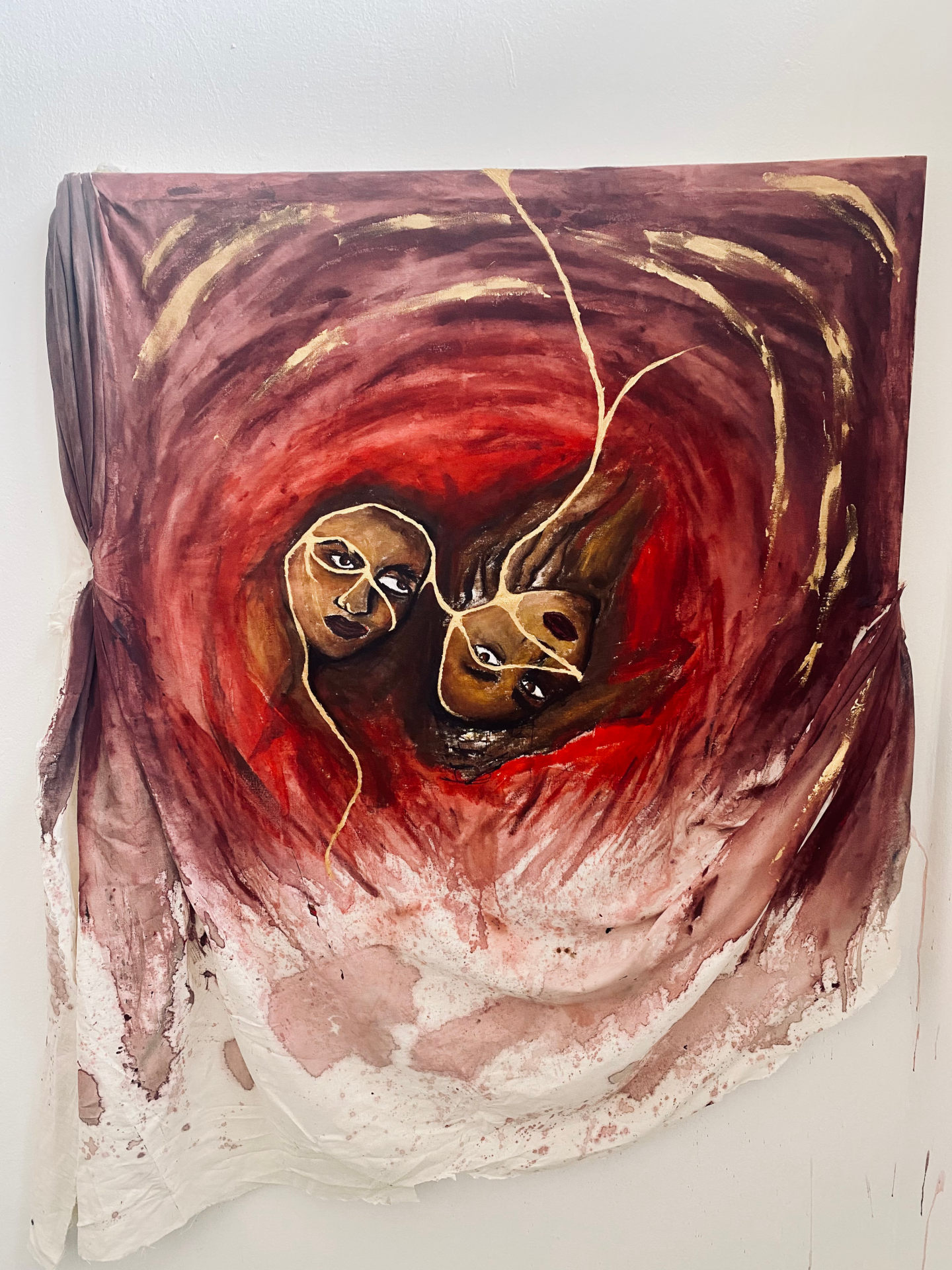 Sculpture of two female faces bound inside flesh-like canvas