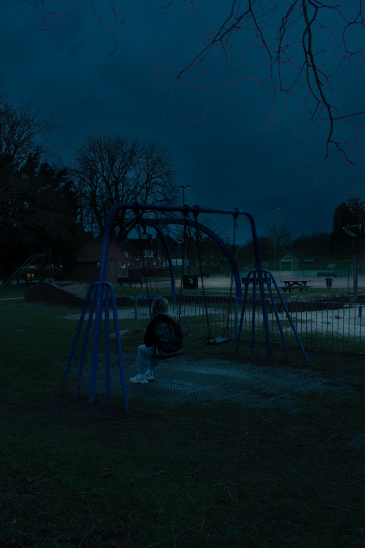 Photo of girl on swing in park on cloudy evening
