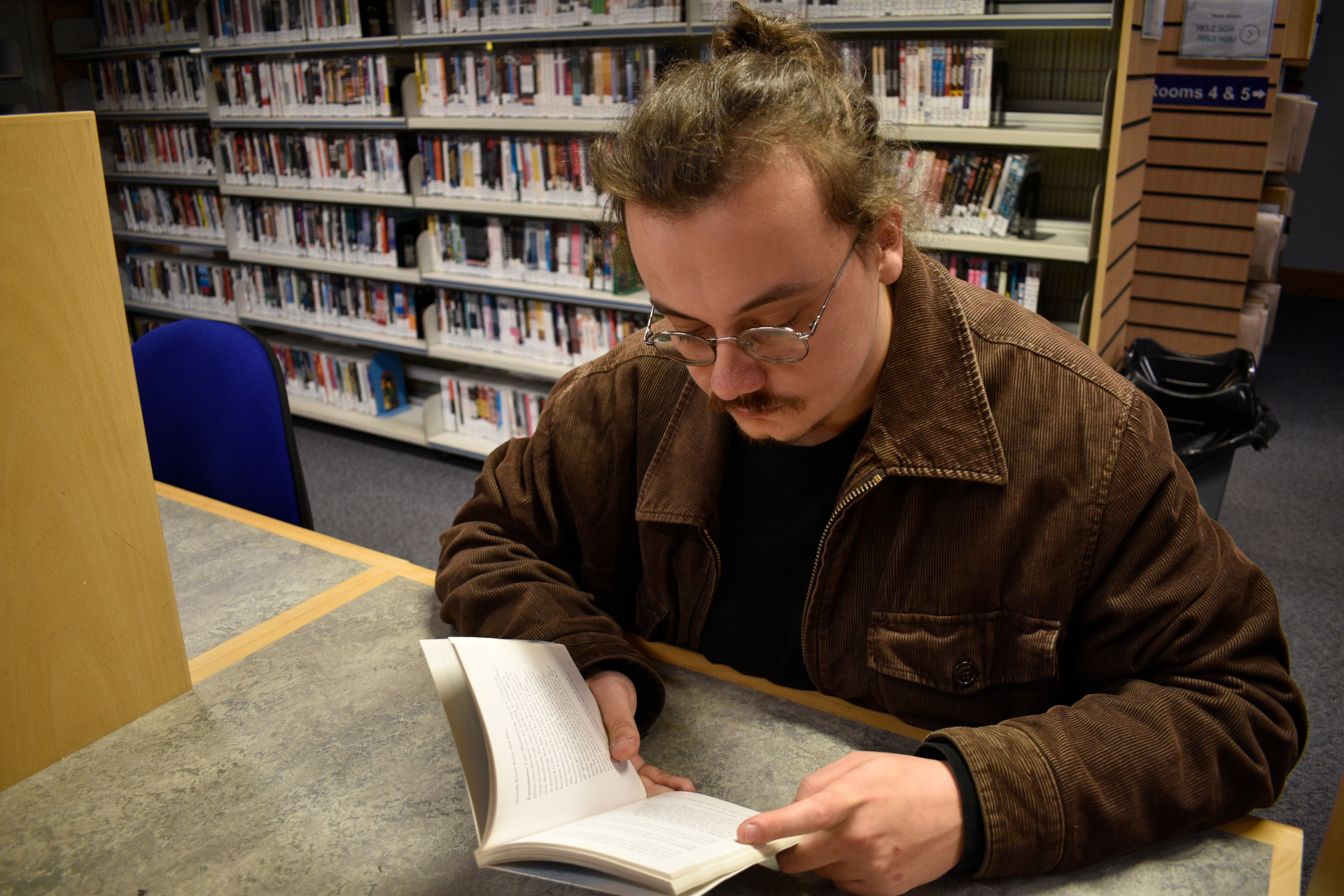 Sam Millar reading book in ARU library