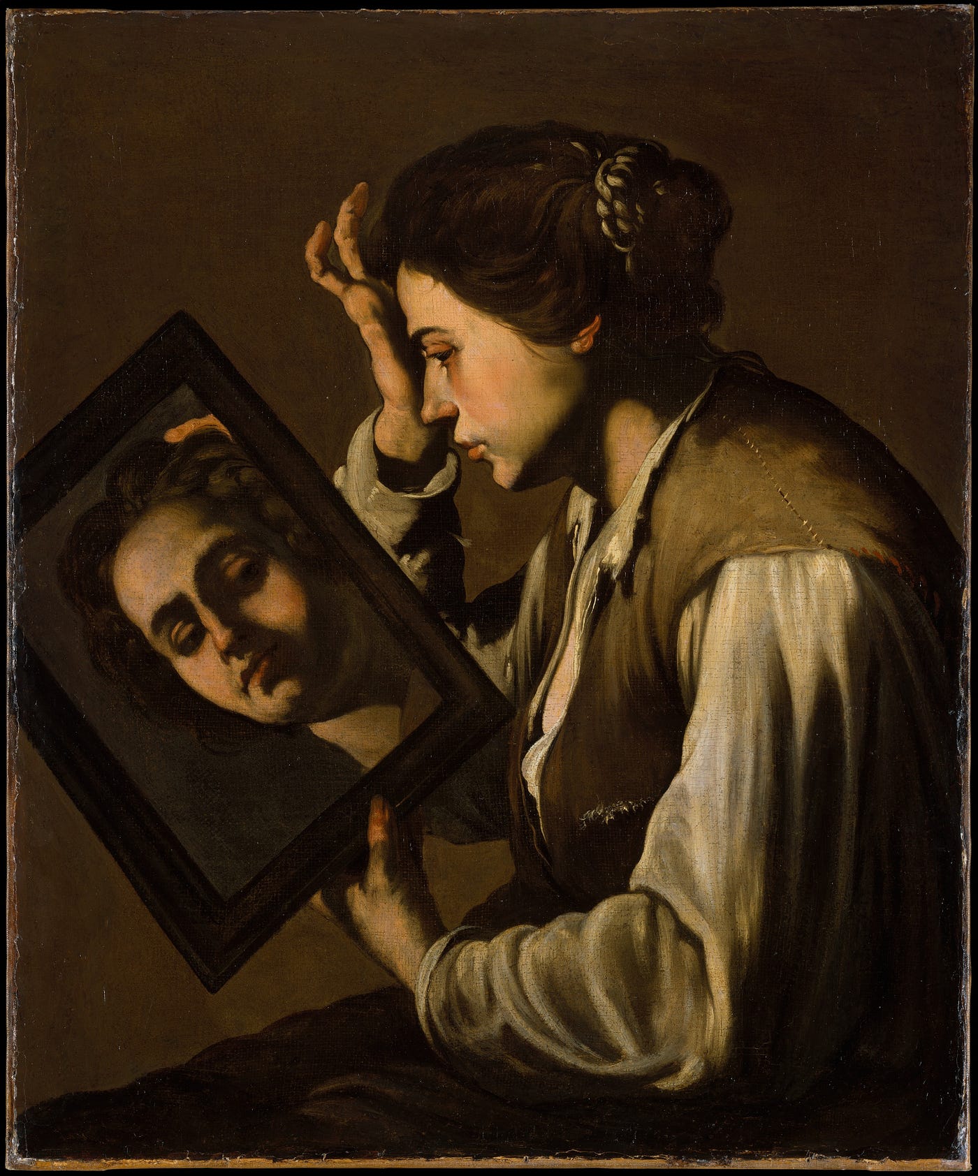 Image of women holding a mirror to her face