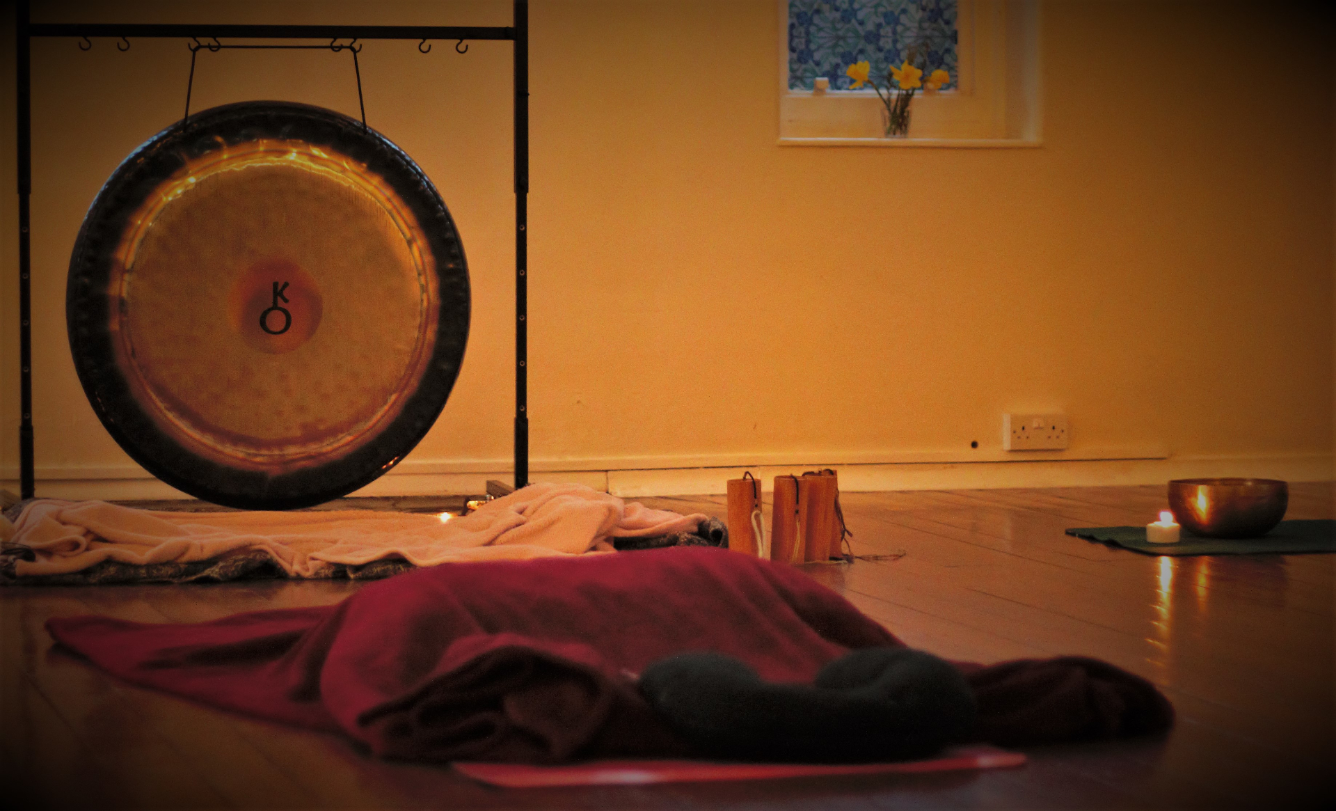 Therapy space with gong, blankets, candles and bowl