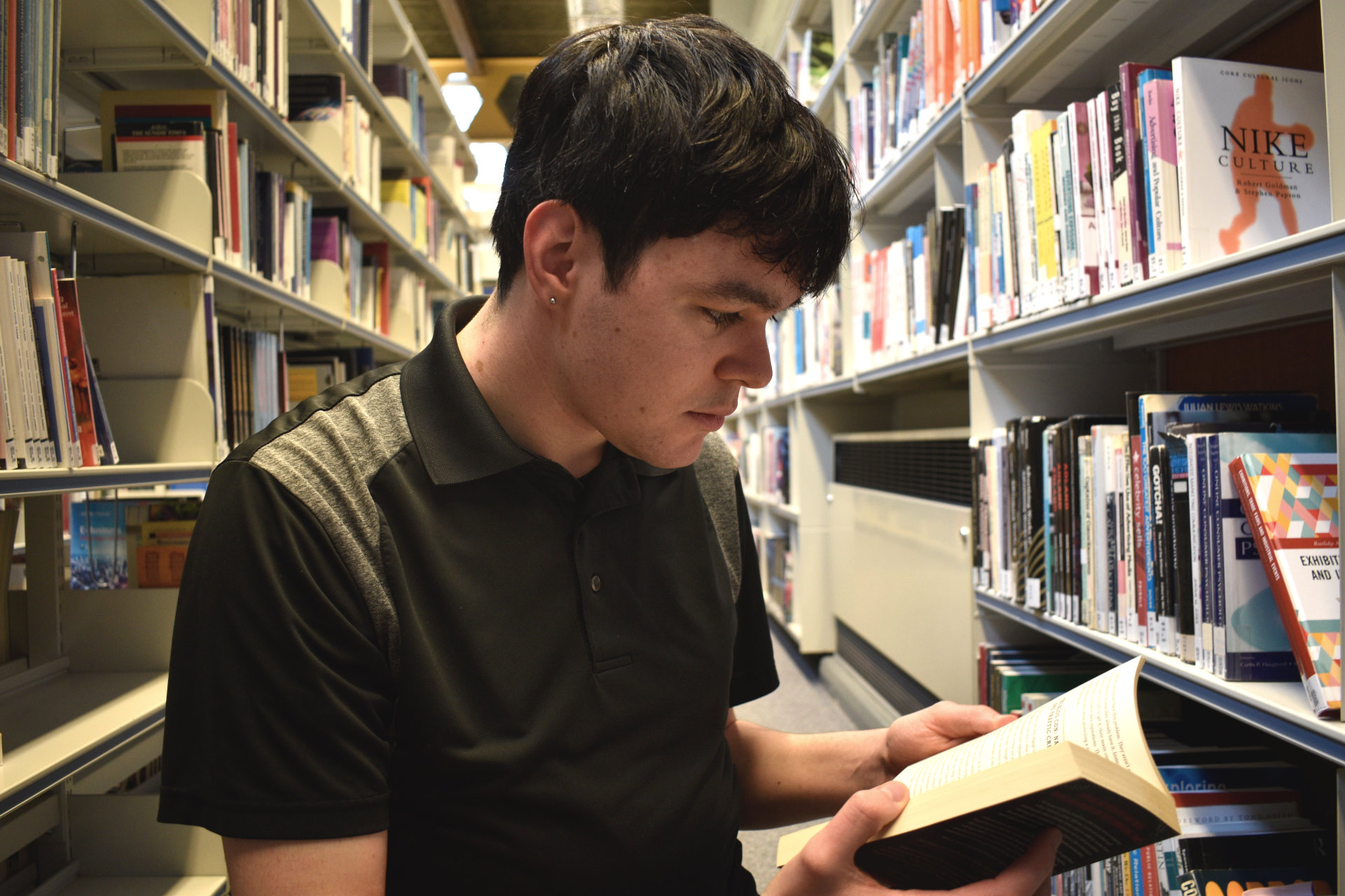 Luke Ford-Busson reading a book in ARU Cambridge library