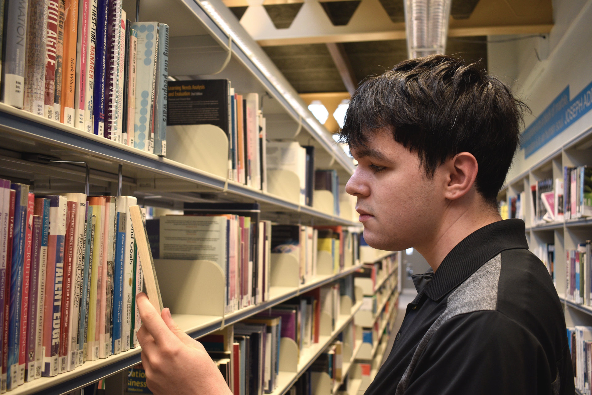 Luke Ford-Busson browsing books in ARU Cambridge library