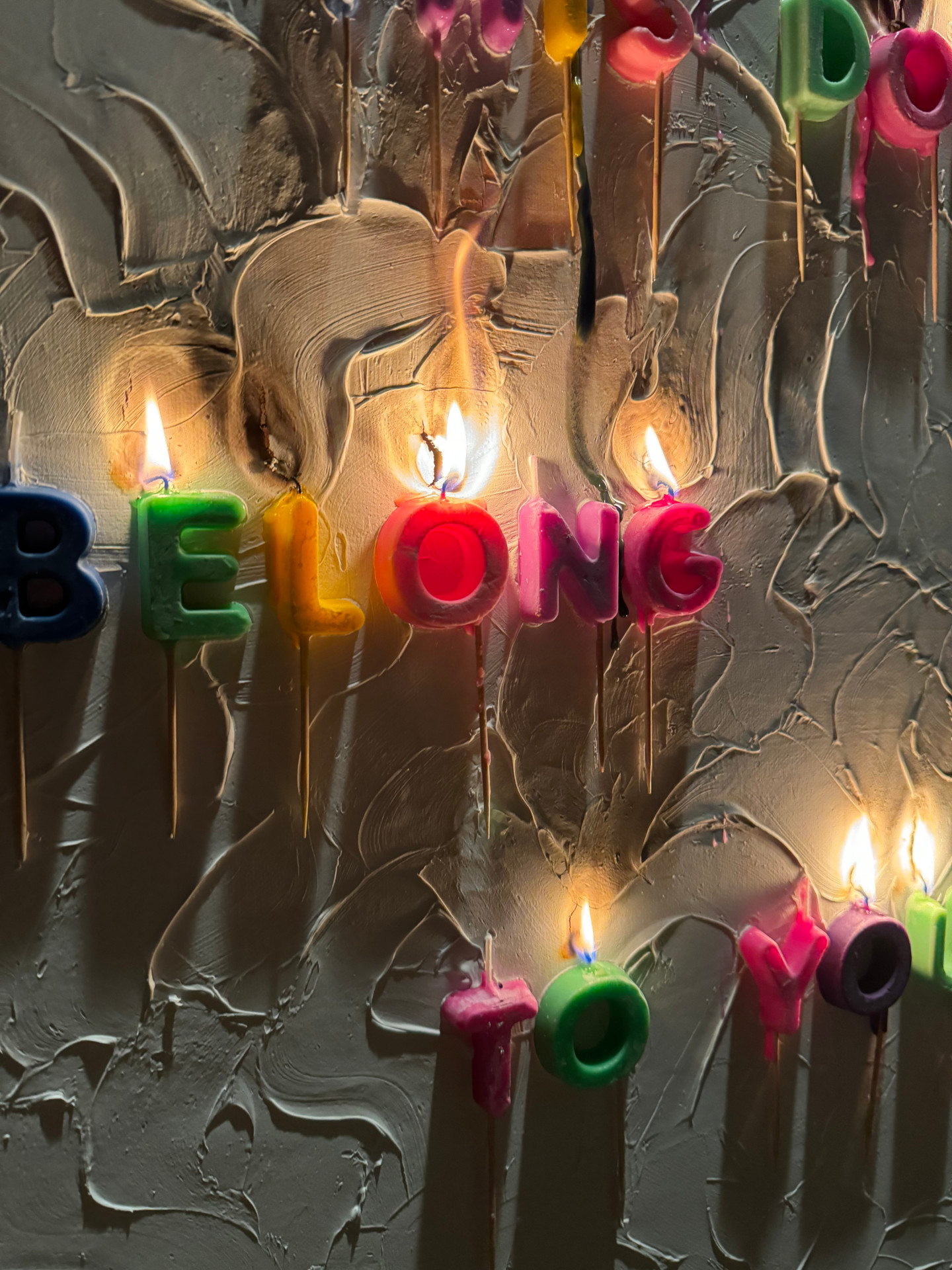 Photo of fridge magnets message on canvas with candles burning above