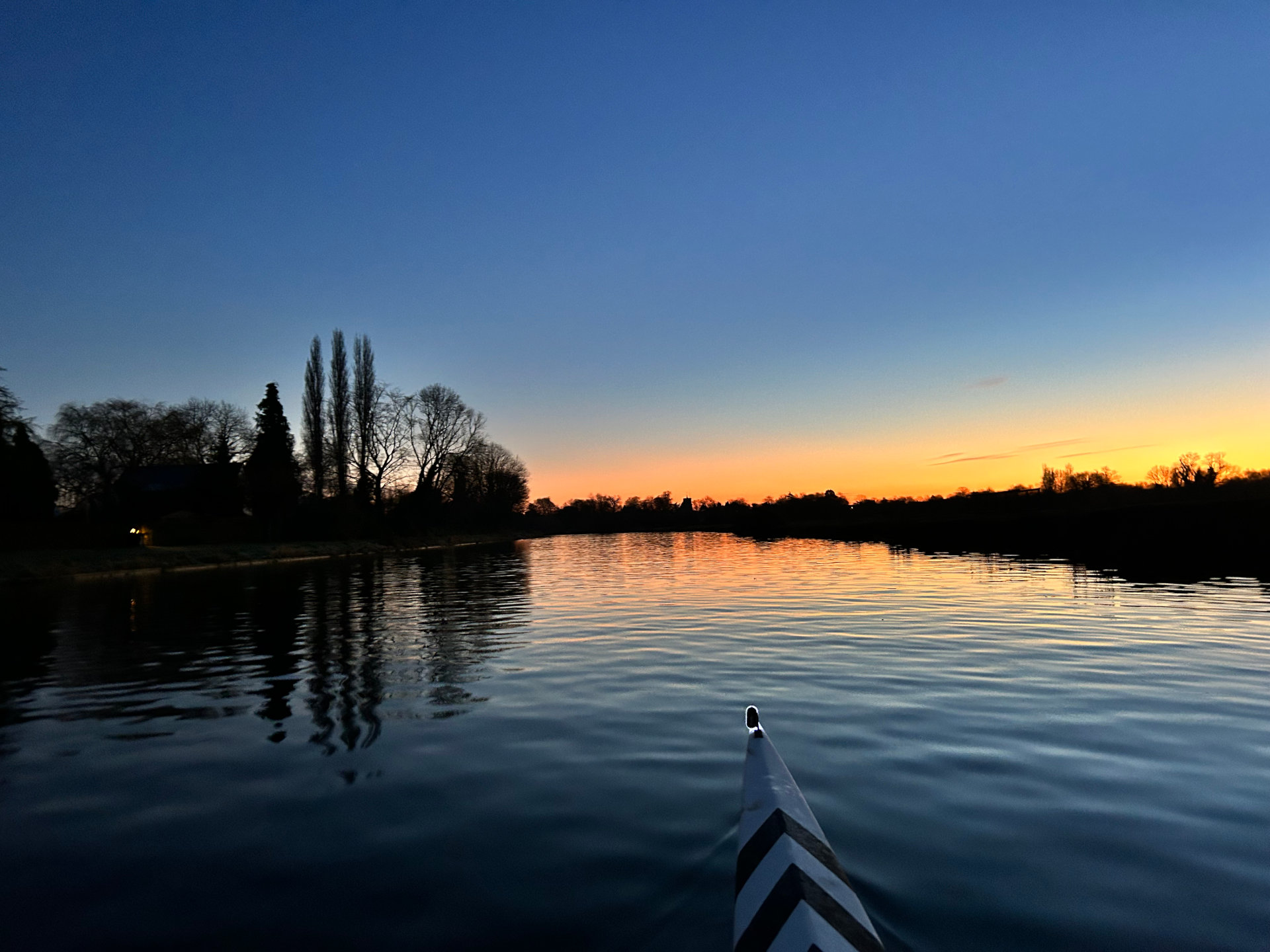 Photo of canoe tip on river at sunset