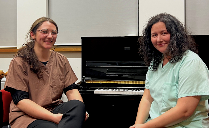 Caterina and Ana sitting in front of standard piano