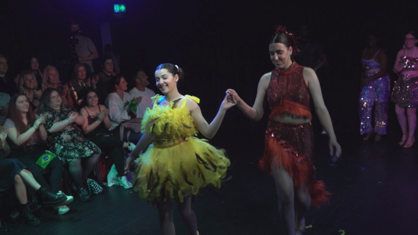 Two female students in dance costumes on stage