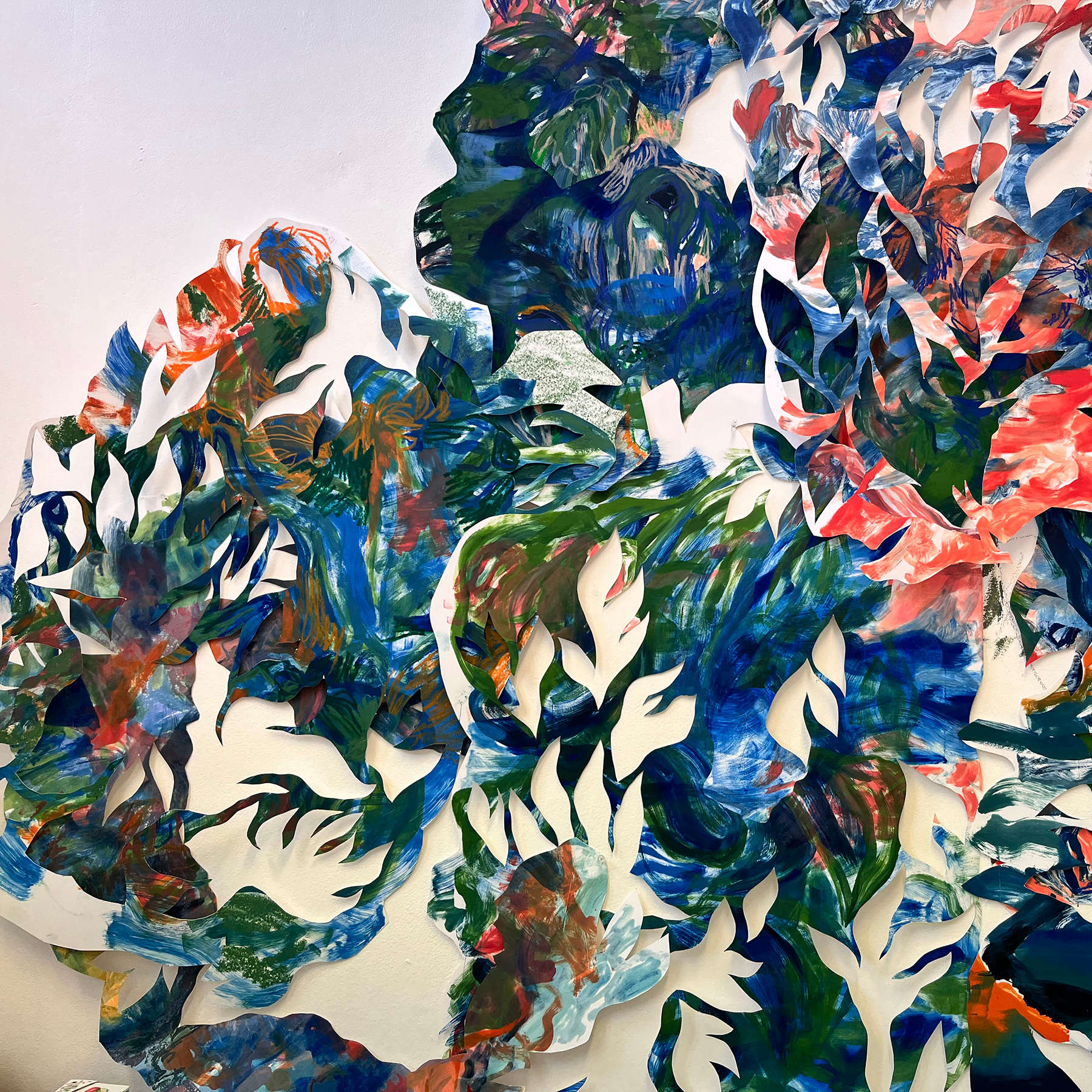 Red, blue and green paint on white foliage-like cut out