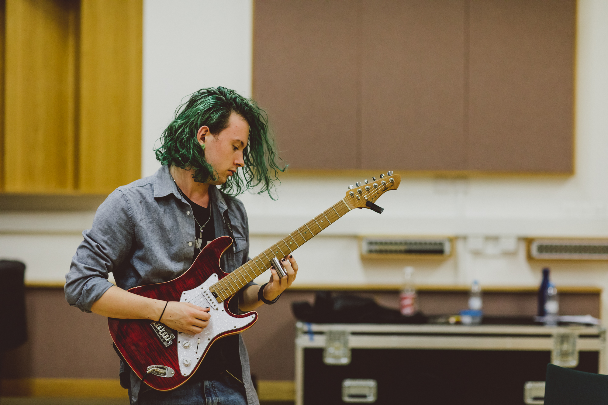 Male student playing electric guitar in Recital Hall
