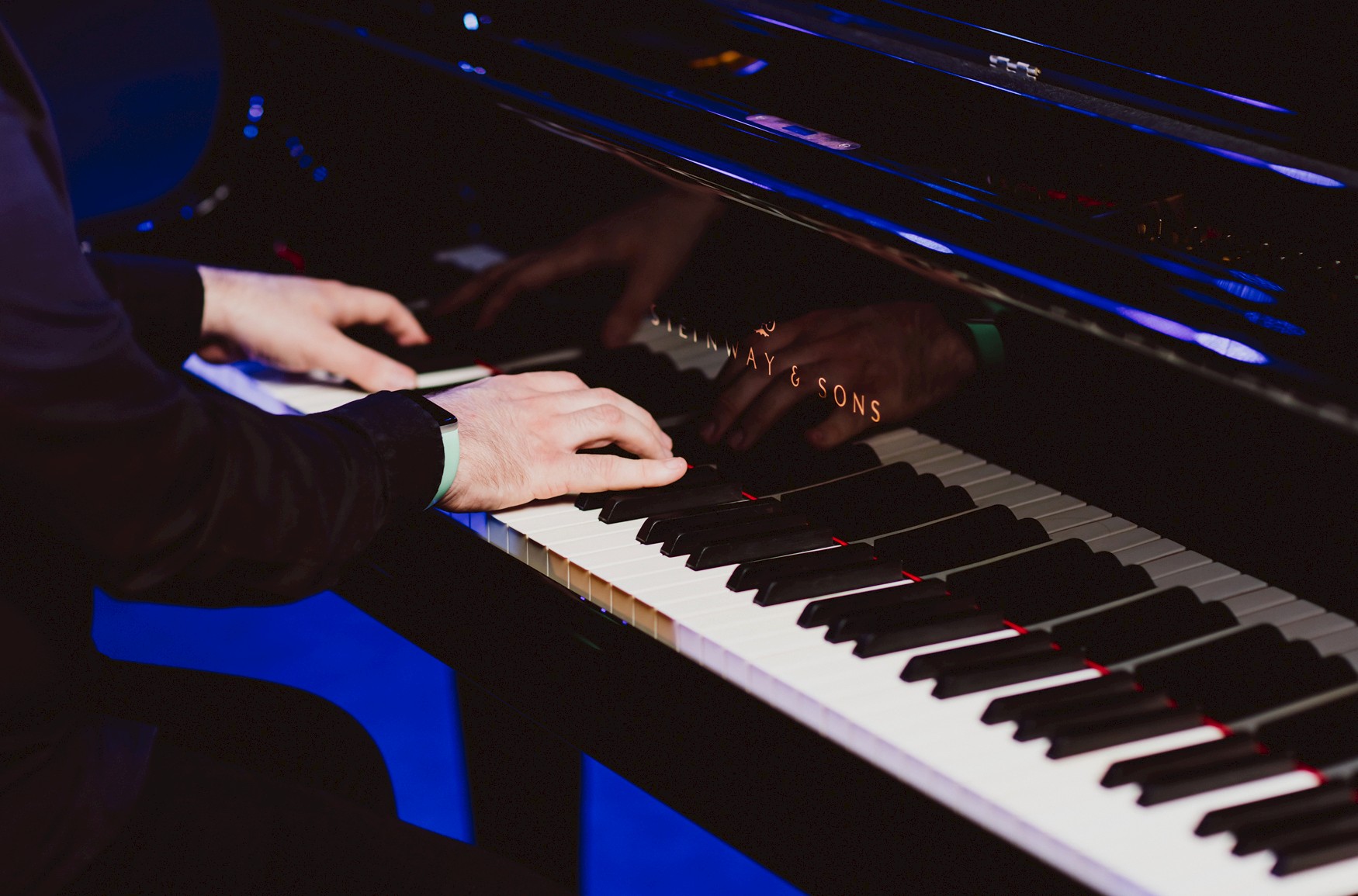 Close up of someone's hands playing a piano