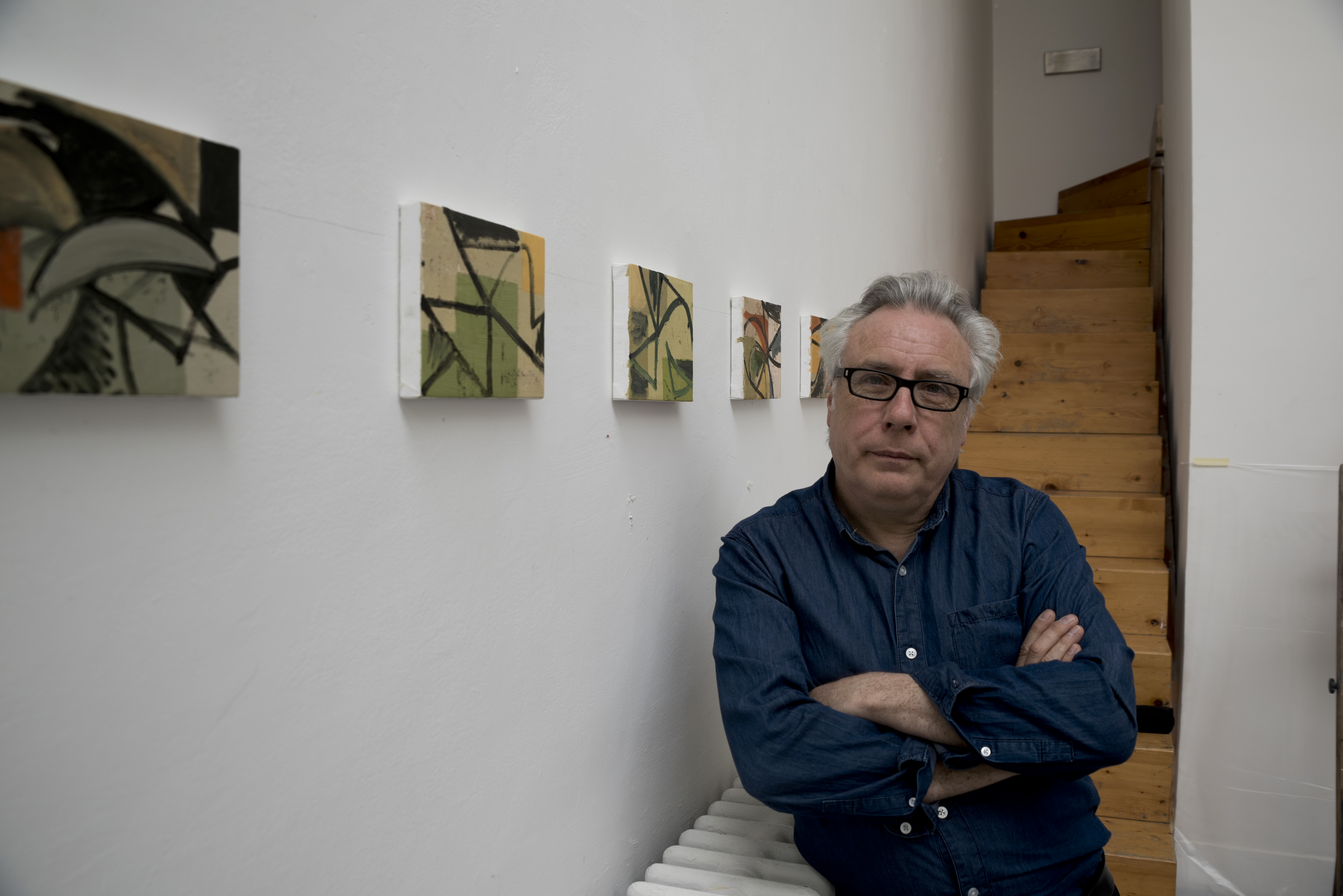David Ryan in an art gallery with some of his paintings