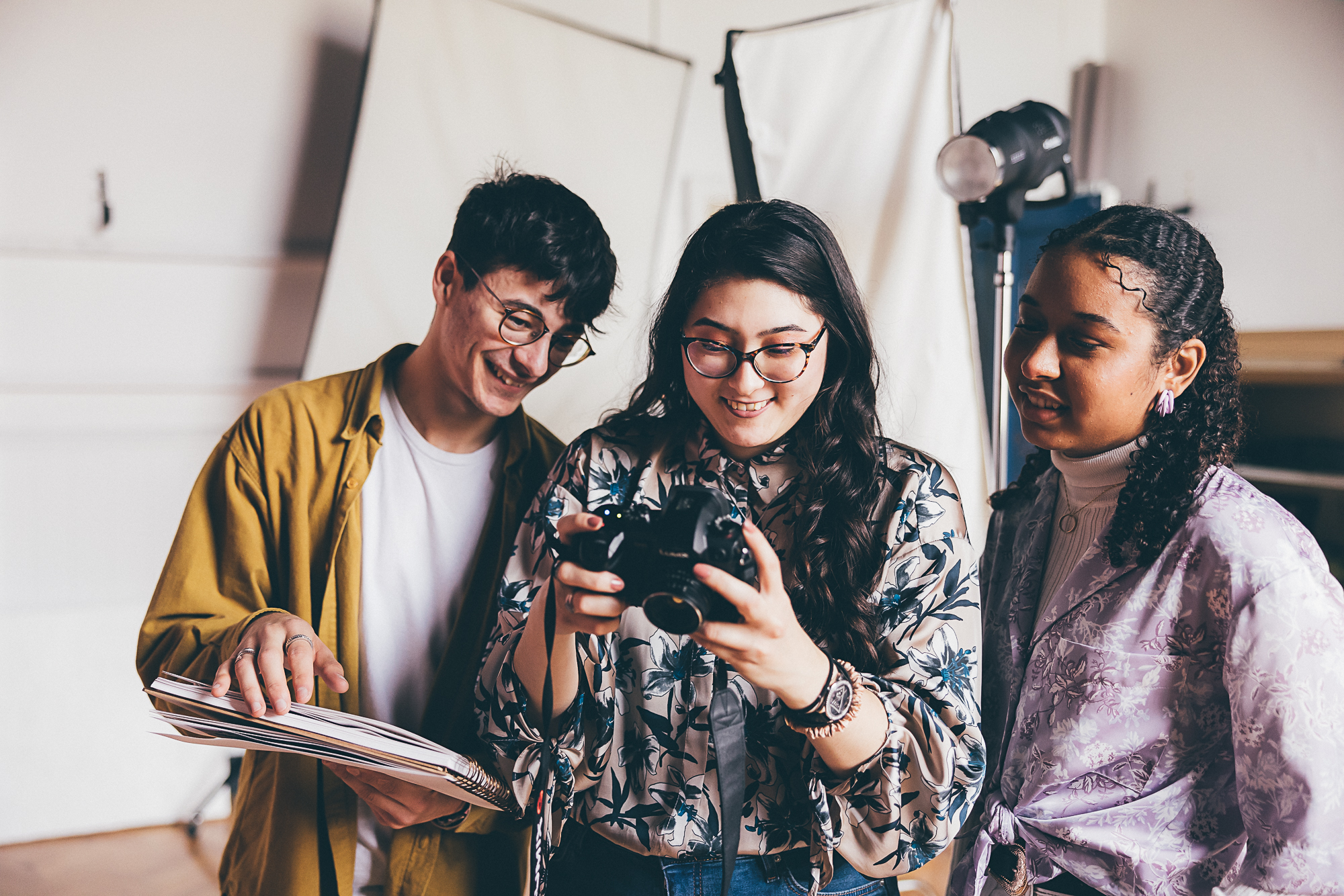 Three students looking at camera in photography studio