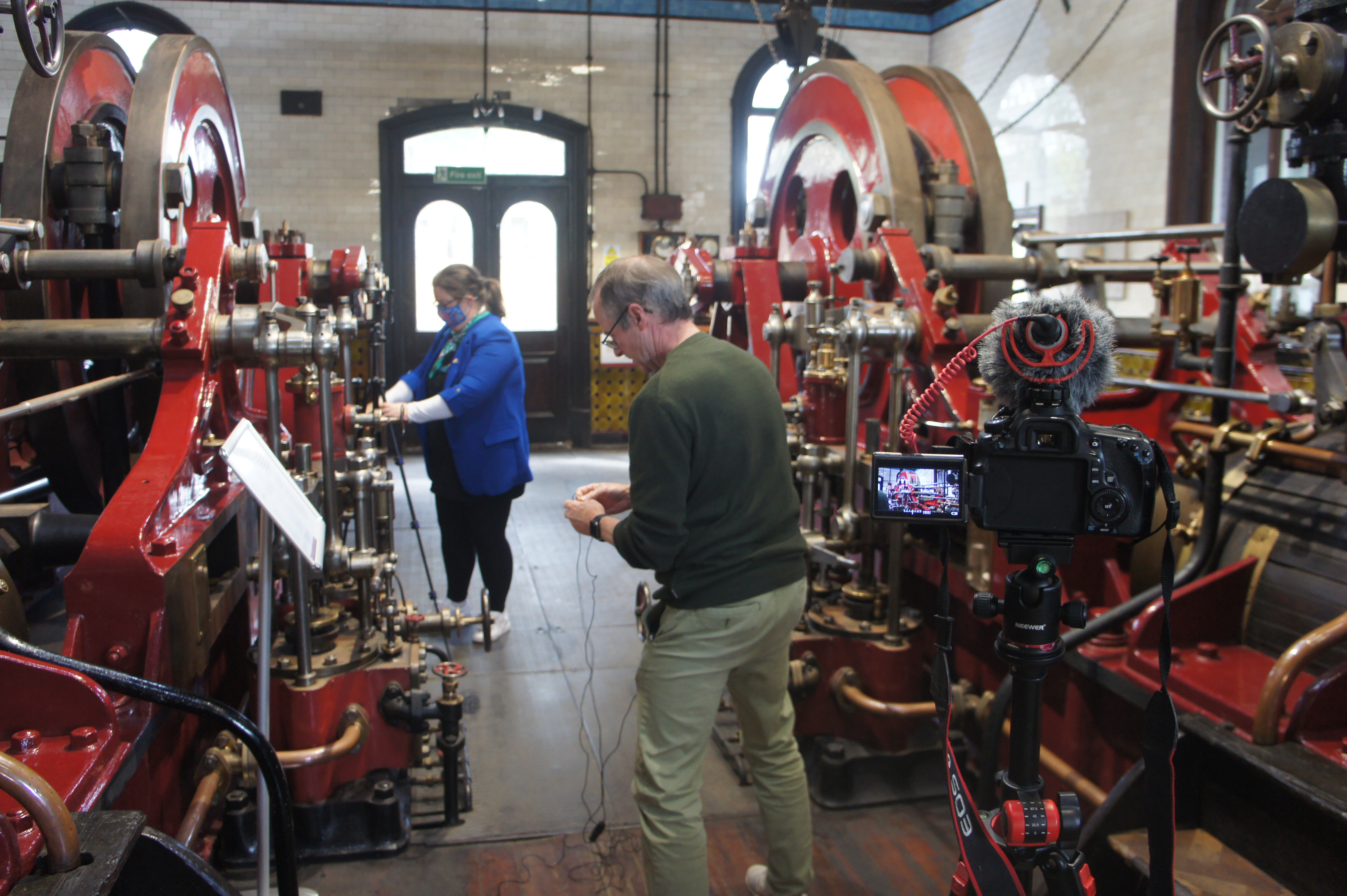 A man and woman in a gallery of industrial machinery