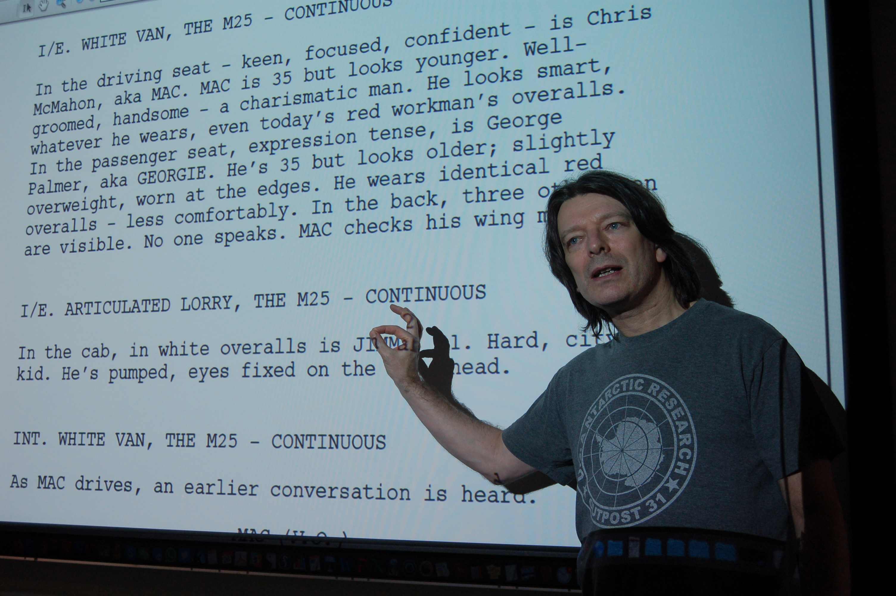 Toby Venables in front of a screen of text from a screenplay