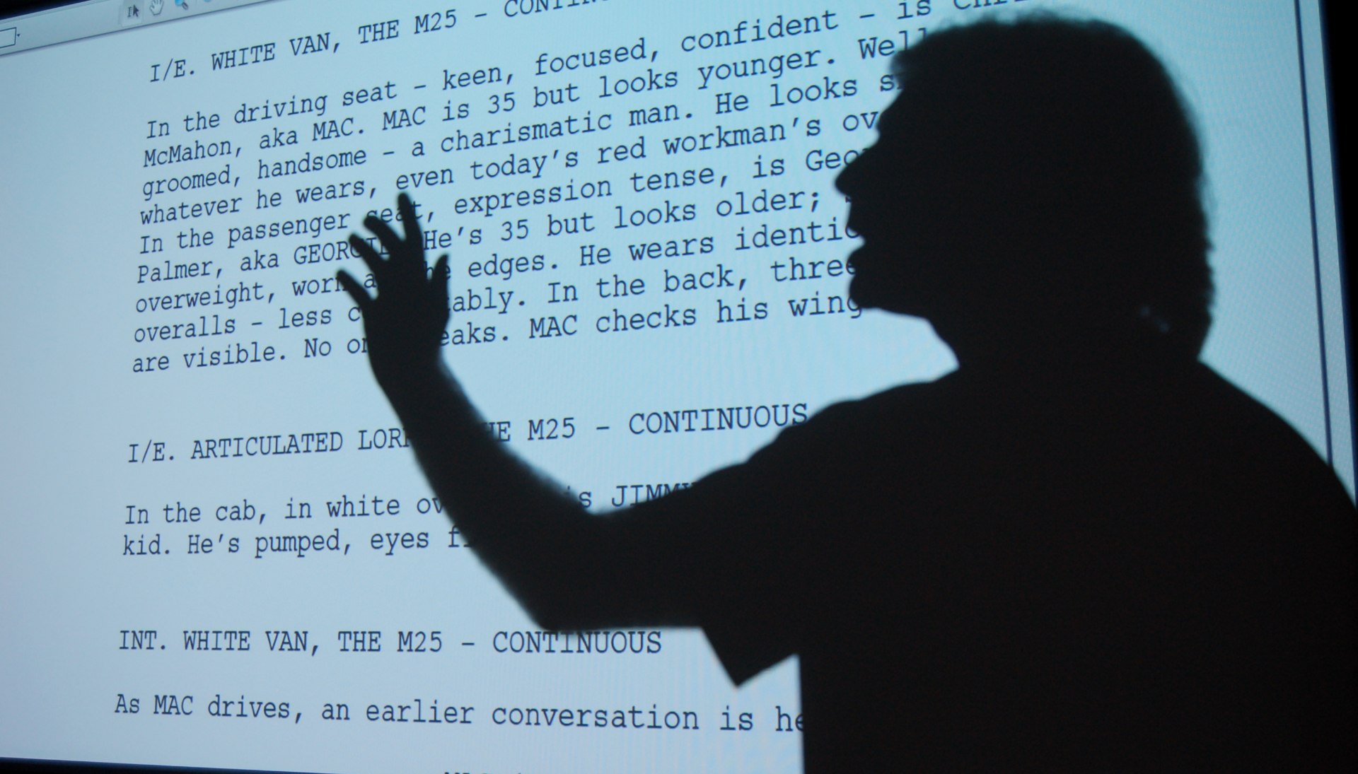 Toby Venable's silhouette in front of a screen showing text from a screenplay