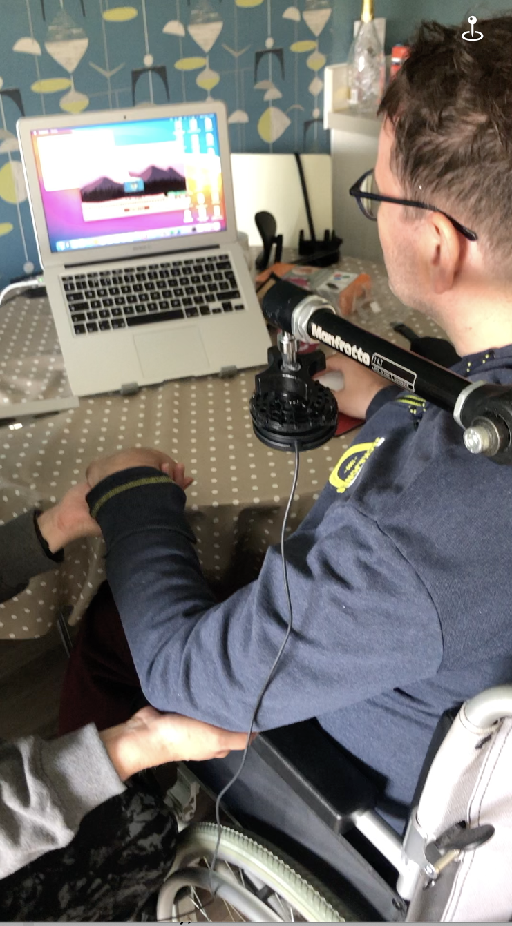 A person seated in a wheelchair in front of a laptop