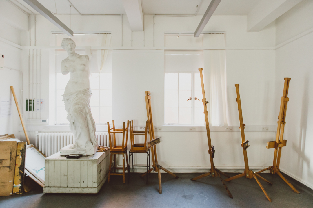 Human sculpture and easels in airy room