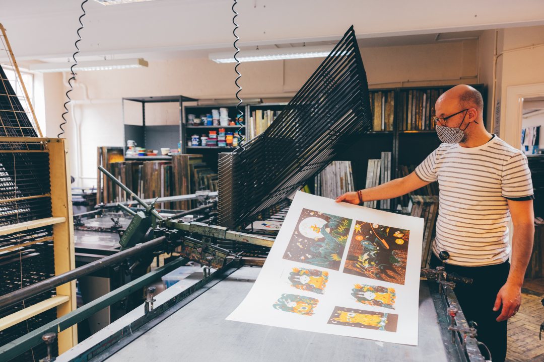 Male student looking at art in print room