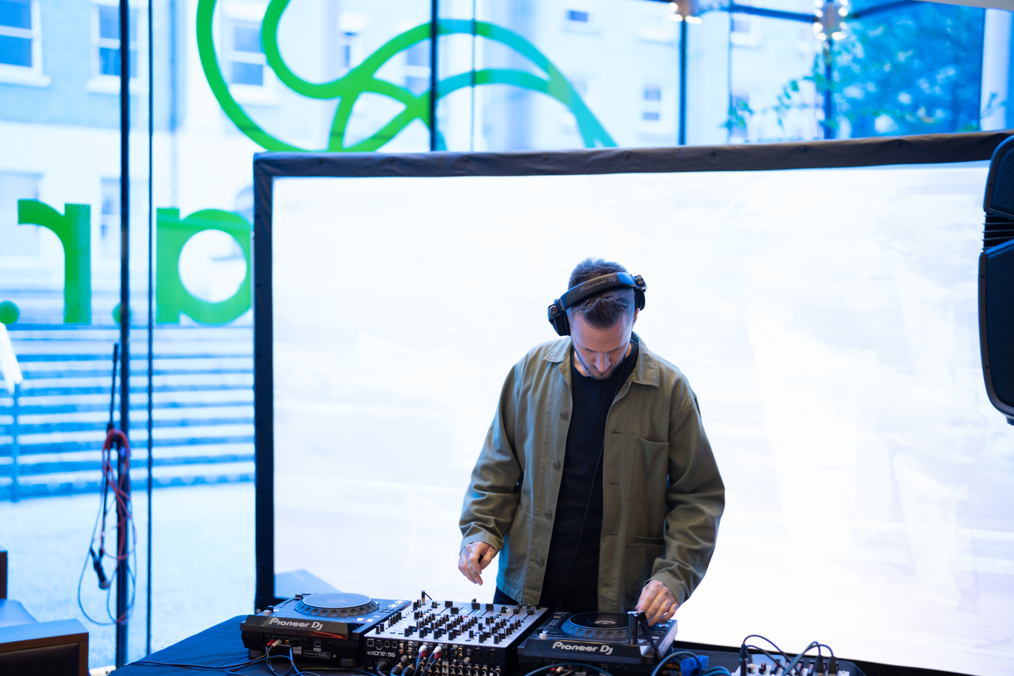 DJ using deck in front of large videos screen