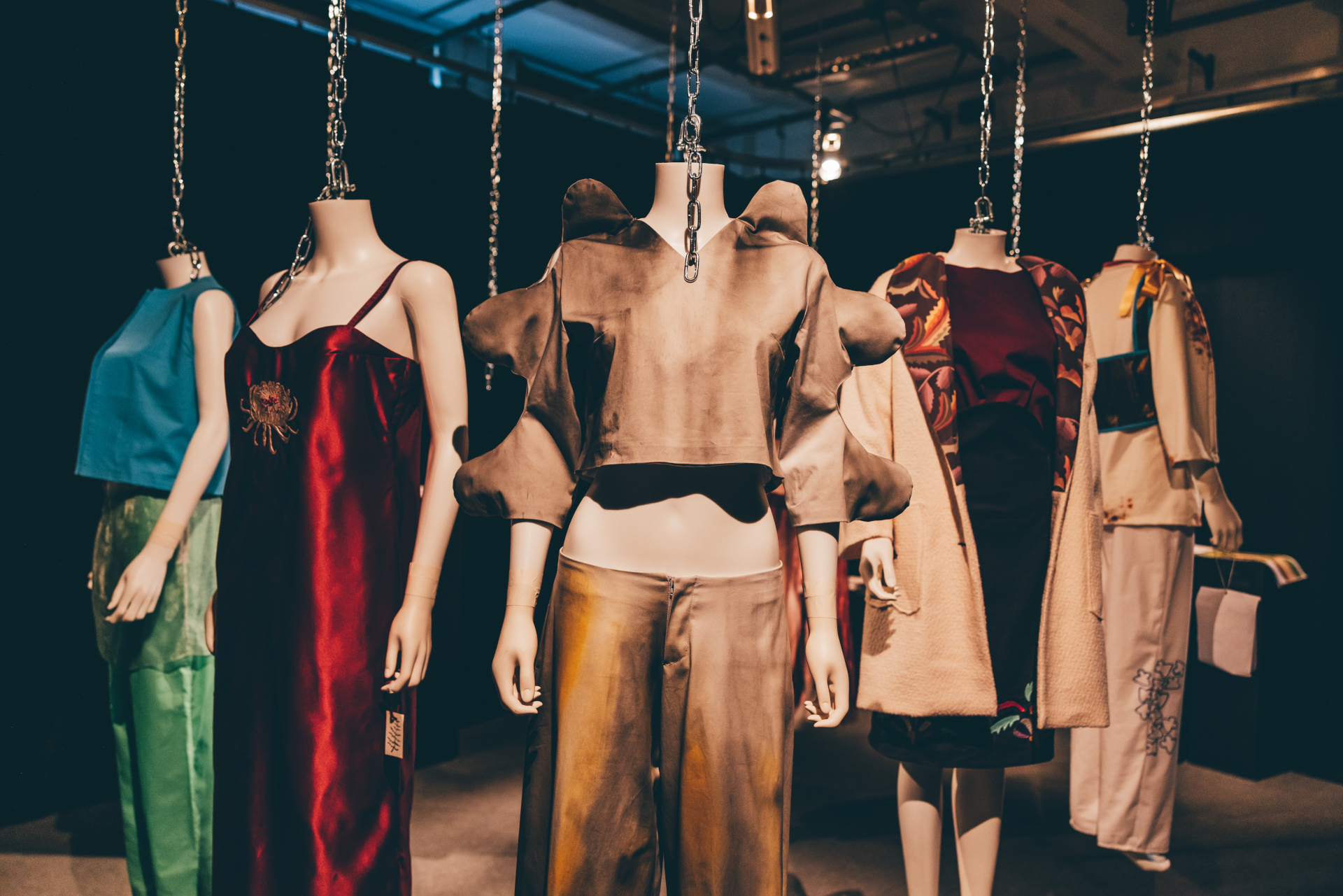 Headless mannequins in clothes designs hanging from ceiling