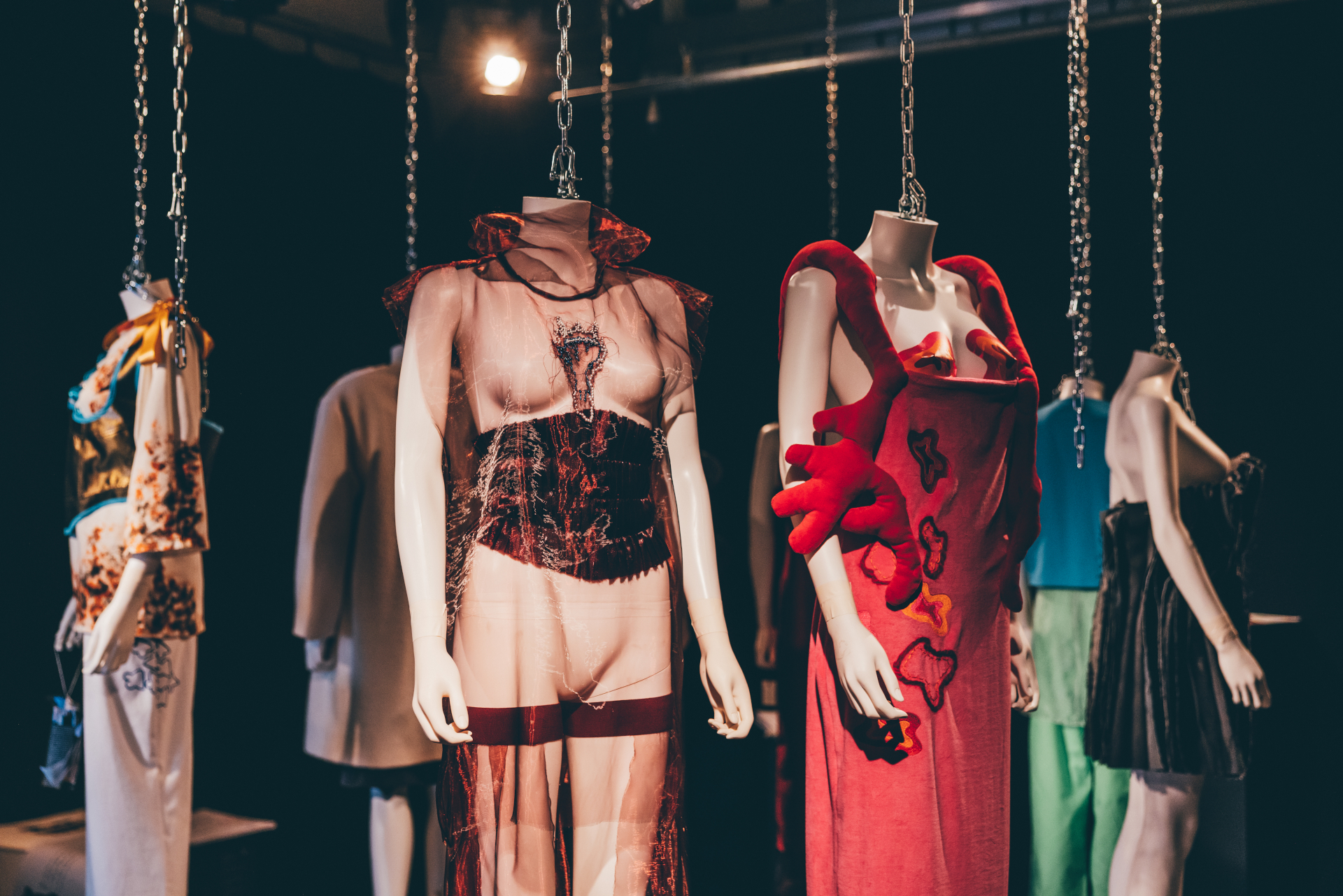 Headless mannequins wearing clothes designs hanging from ceiling