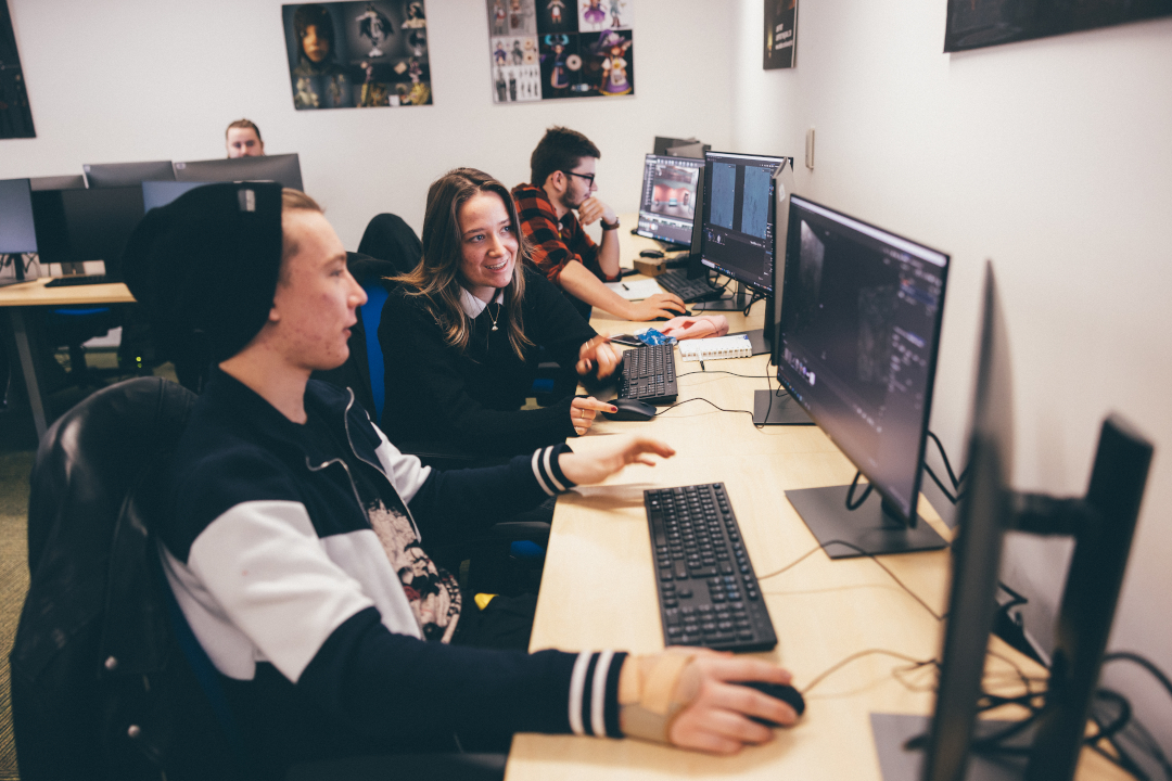 Four students using computers in games development studio