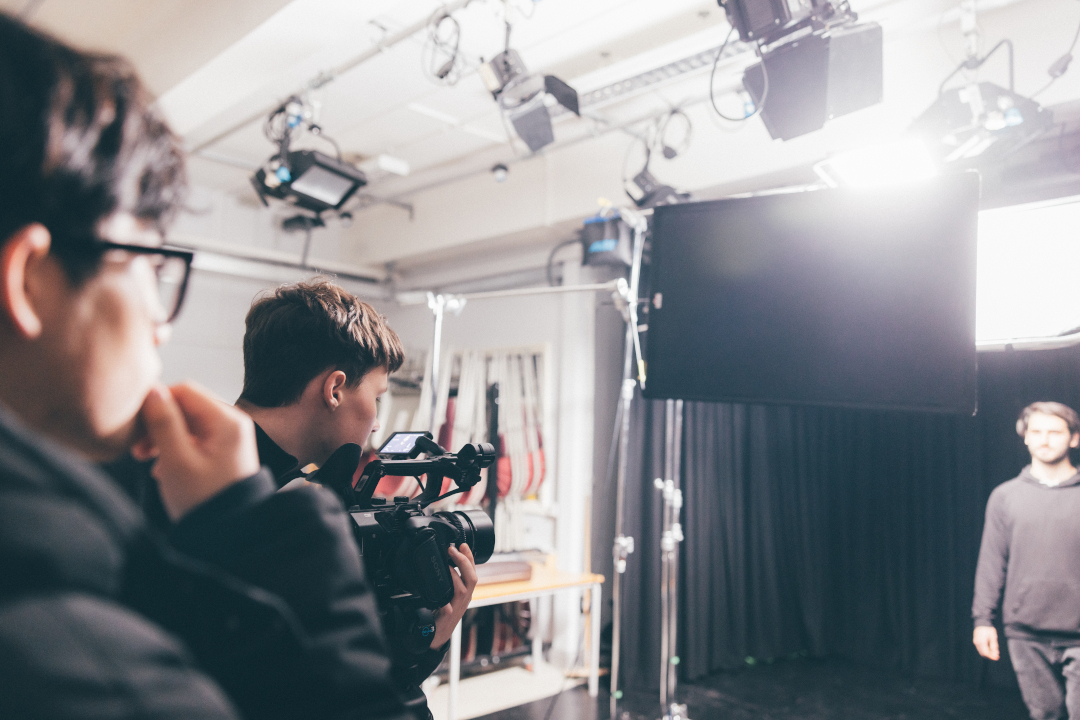 Young men using camera in film studio