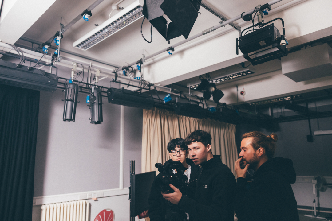 Young men using camera in film studio