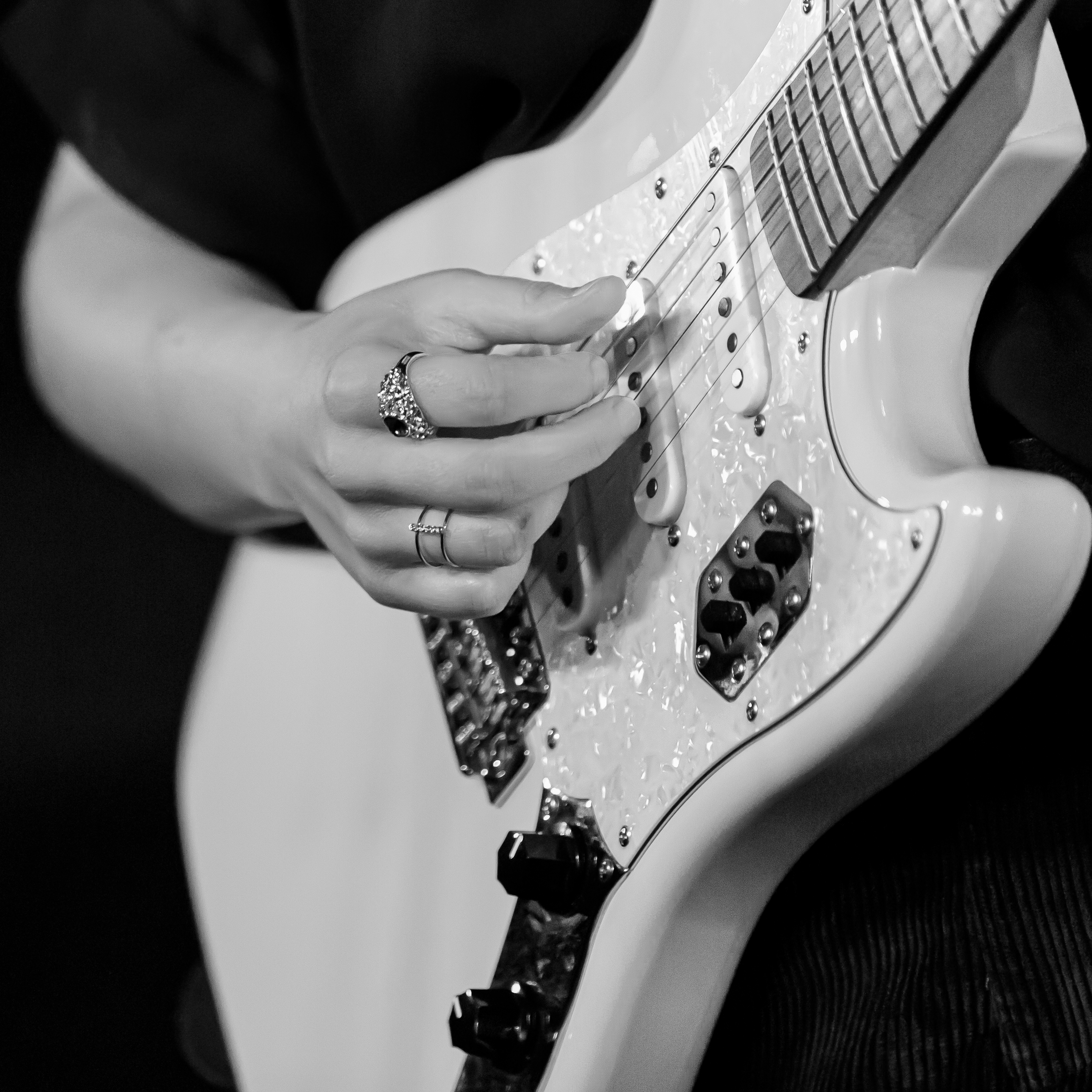 A hand playing a guitar.