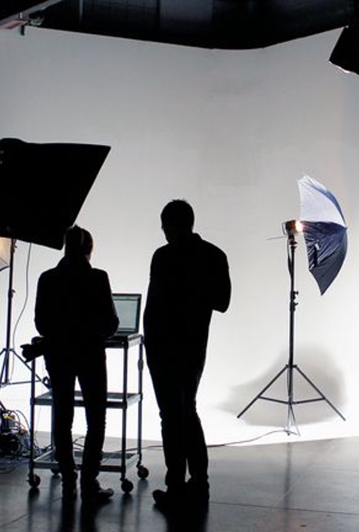 People standing in front of a photography studio set.