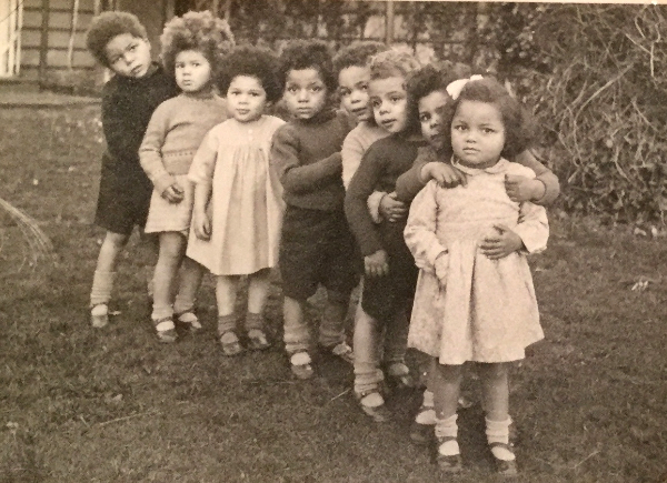 black and white photo of children standing in a row in garden