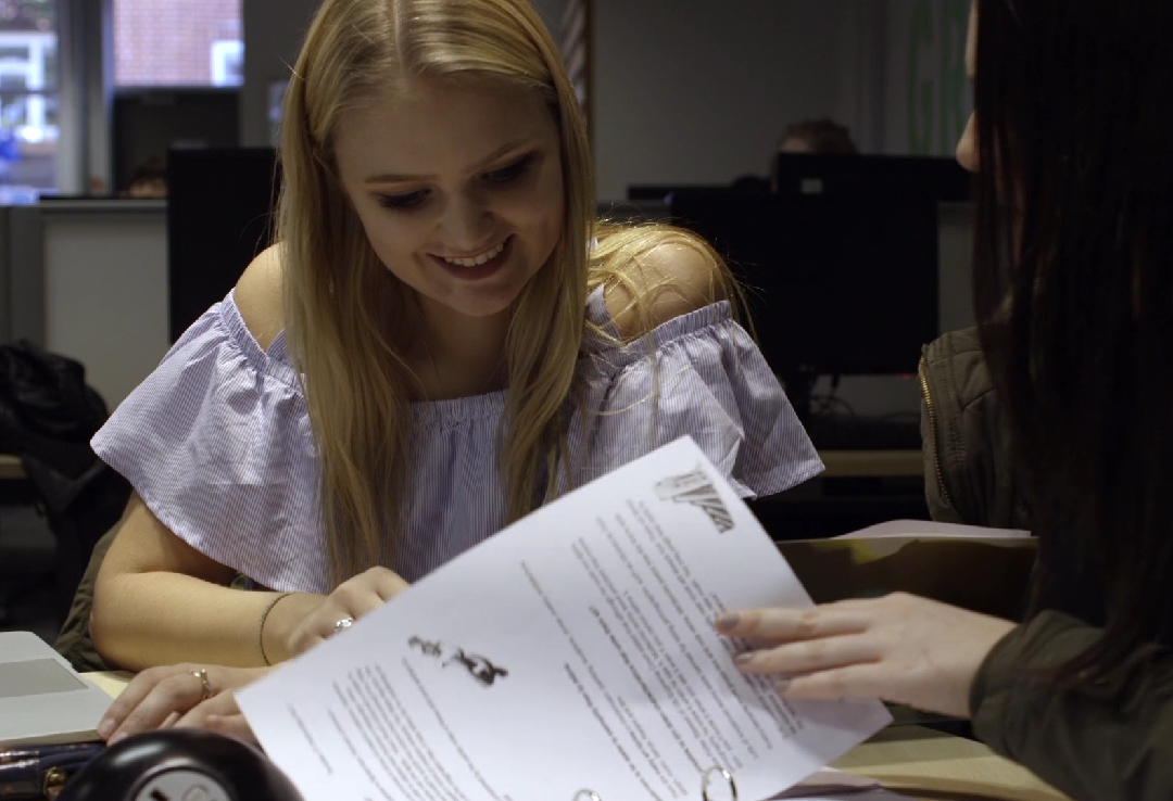 Female students reading documents