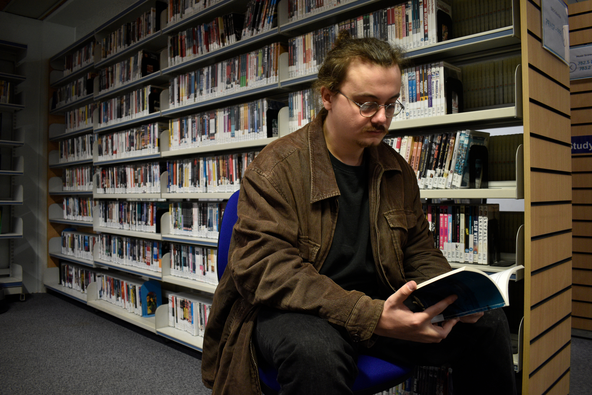 Sam Millar reading book in library